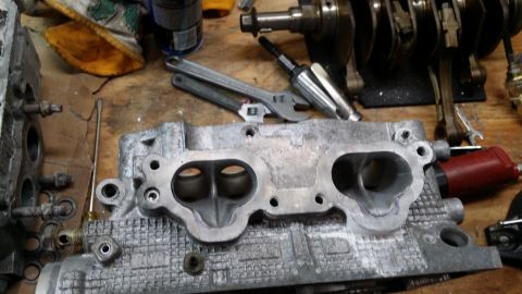 2007 Subaru Impreza - Engine intake manifold and crankshaft on a workbench, suggesting automotive repair or modification.
