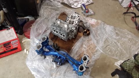 2007 Subaru Impreza - Engine components, including a block and intake manifold, are laid out on plastic sheeting next to a red tool kit.