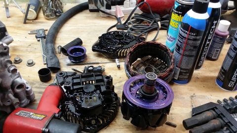 2007 Subaru Impreza - Various parts of a disassembled alternator are laid out on a workbench alongside tools and spray cans.