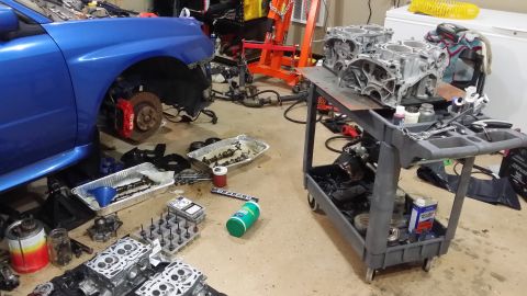2007 Subaru Impreza - 2007 Subaru Impreza undergoing engine rebuild, with parts laid out in a garage setting.