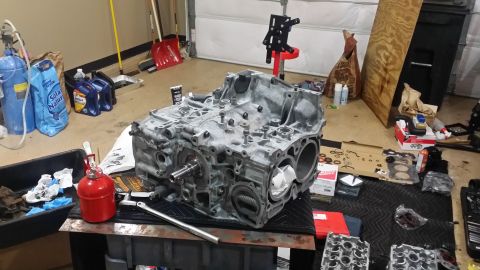 2007 Subaru Impreza - Engine block on a workbench, surrounded by tools and parts, in a garage setting.