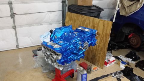 2007 Subaru Impreza - A freshly painted blue engine sits on a stand, with parts of a blue car visible in the background.