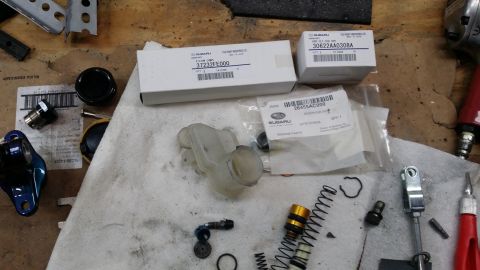 2007 Subaru Impreza - Various Subaru brake master cylinder parts are arranged on a workbench.