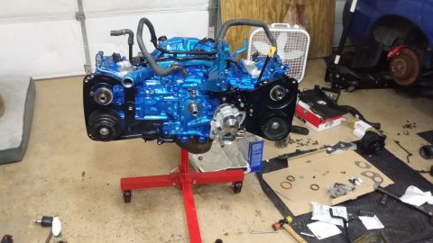 2007 Subaru Impreza - Engine assembly on a stand, with various engine parts and tools laid out on the garage floor.
