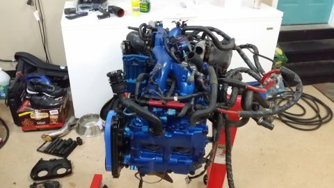 2007 Subaru Impreza - A blue Subaru engine is mounted on a stand, ready for installation or work. The engine bay is filled with hoses and wiring.