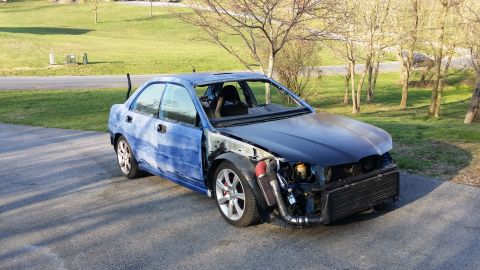 2007 Subaru Impreza - This Subaru Impreza is missing several body panels and has aftermarket engine modifications. The interior shows a racing seat.