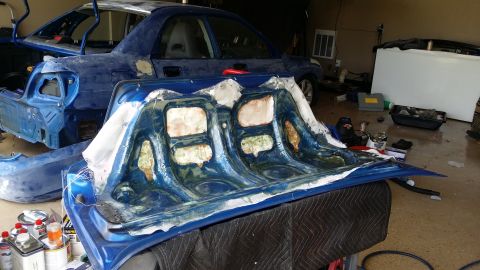 2007 Subaru Impreza - Car body panels are disassembled and laid out in a garage for repair or modification.