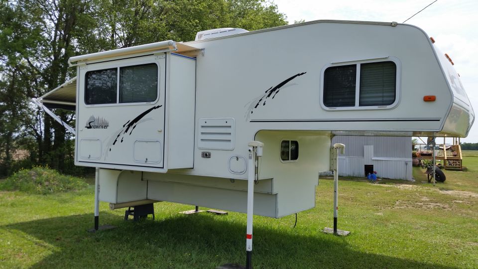 White truck camper with slide-out and awning