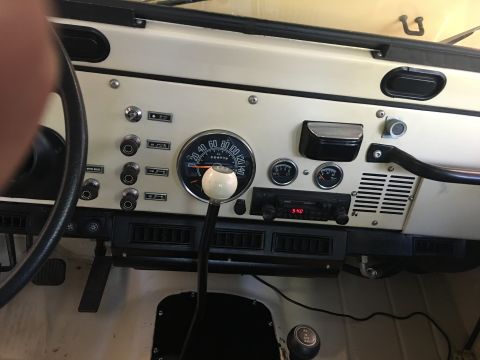 1986 Jeep Wagoneer - The interior dashboard of a Jeep CJ features a prominent white shifter knob and various gauges.