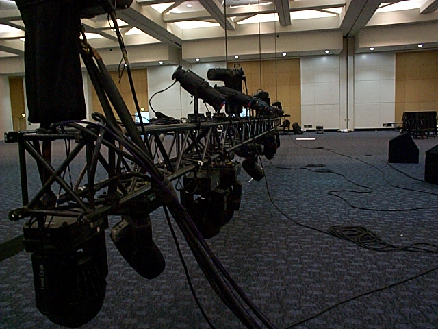 Stage lighting truss with multiple lights and cables in a convention hall