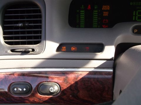 2001 Mercury Grand Marquis - The dashboard shows illuminated warning lights for the air bag, ABS, and brake system.