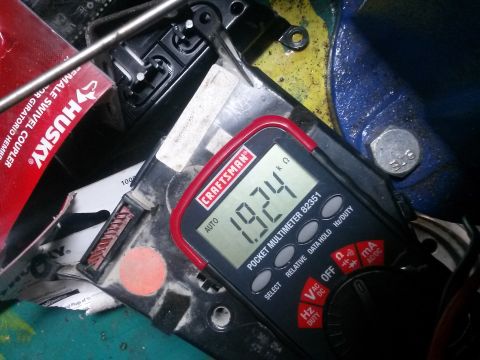 1996 Ford Bronco - Digital multimeter reading resistance, surrounded by various tools and parts.