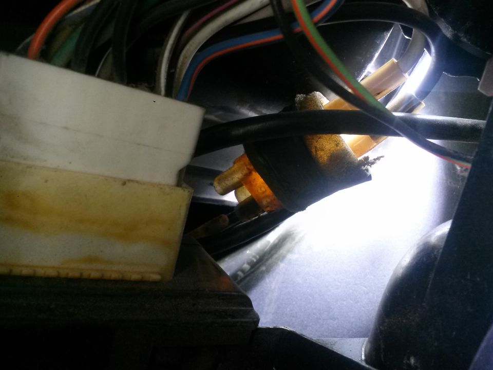 Close-up of a vehicle's wiring harness connector with multiple wires