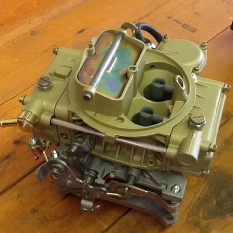 1978 Ford Bronco - A gold-colored carburetor with visible mechanical linkages is shown from a top-down perspective.