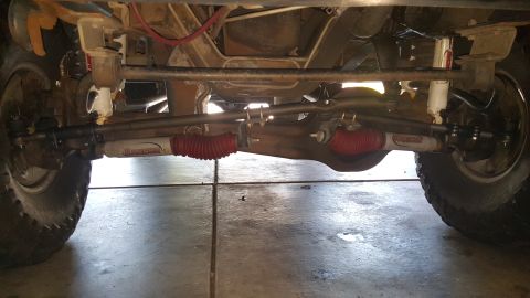 1996 Ford Bronco - Close-up of the steering and suspension system, showing red bellows on the tie rods and white shocks.
