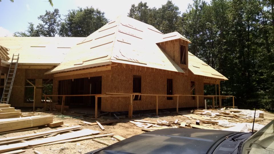 Construction scene with unfinished house and lumber; Supermotors logo visible