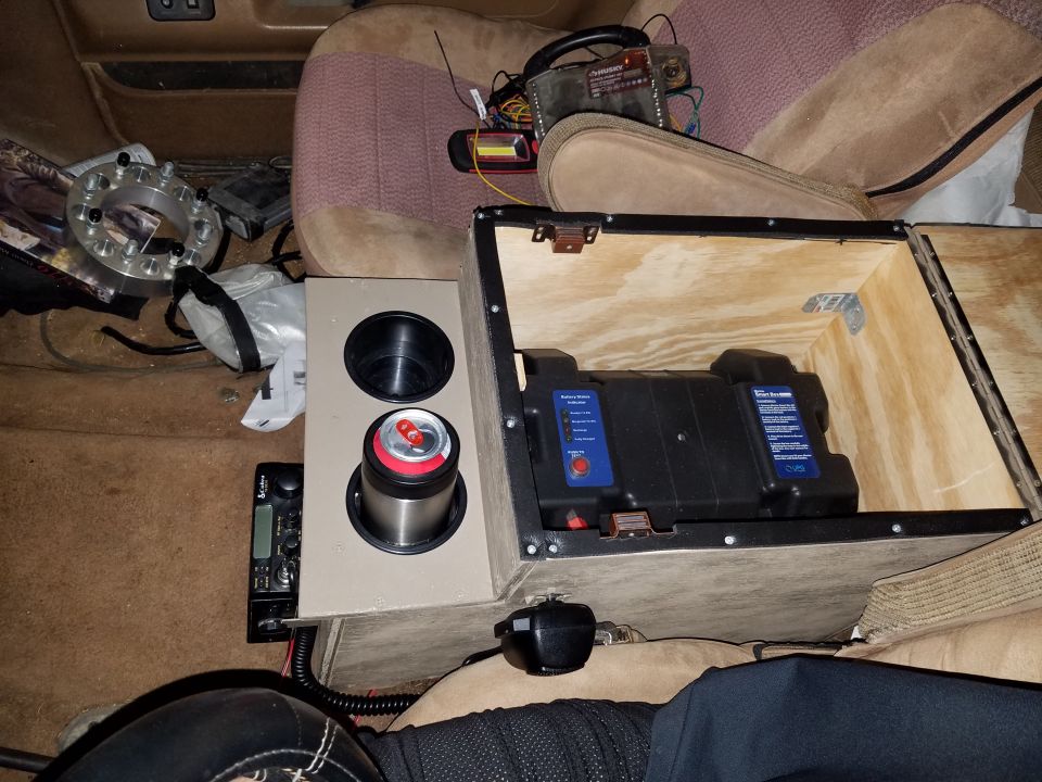 Custom center console with battery, cup holders, and radio installed in a vehicle interior
