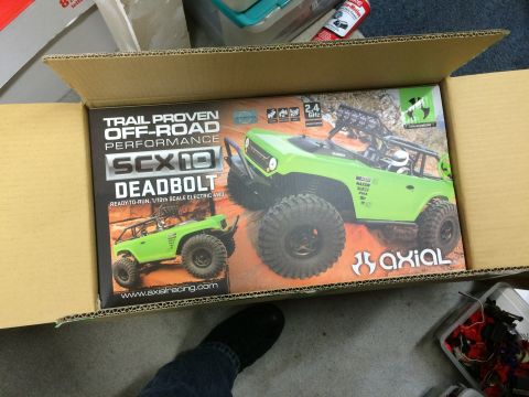 1989 Ford Bronco - Box art for the Axial SCX10 Deadbolt RC car, a lime green body and off-road tires.