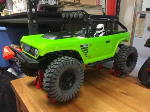 1989 Ford Bronco - This RC rock crawler, labeled 'DEADBOLT', is displayed on red jack stands, ready for off-road action.