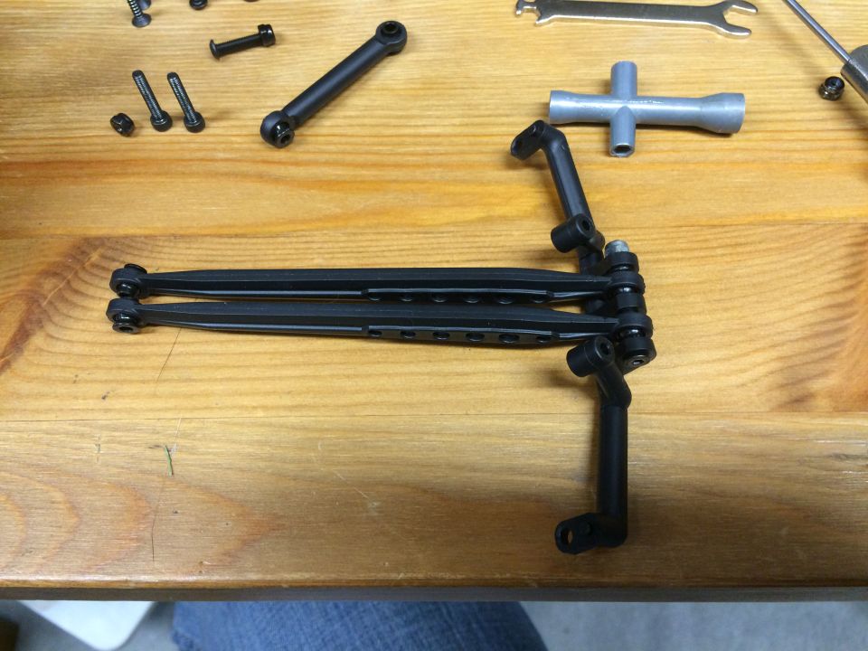 Various small mechanical parts and tools on a wooden table.