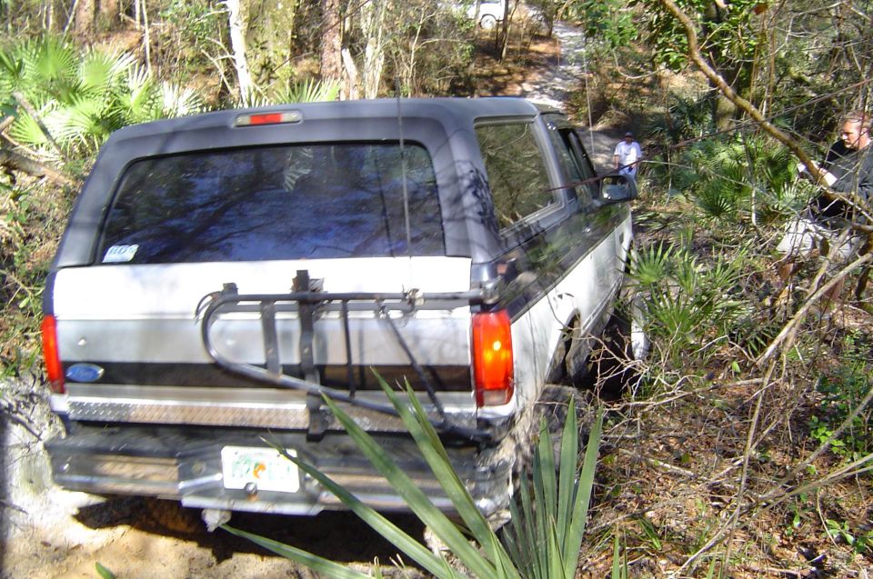 White Ford Bronco off-camber on a sandy Florida palmetto trail with rear tire carrier