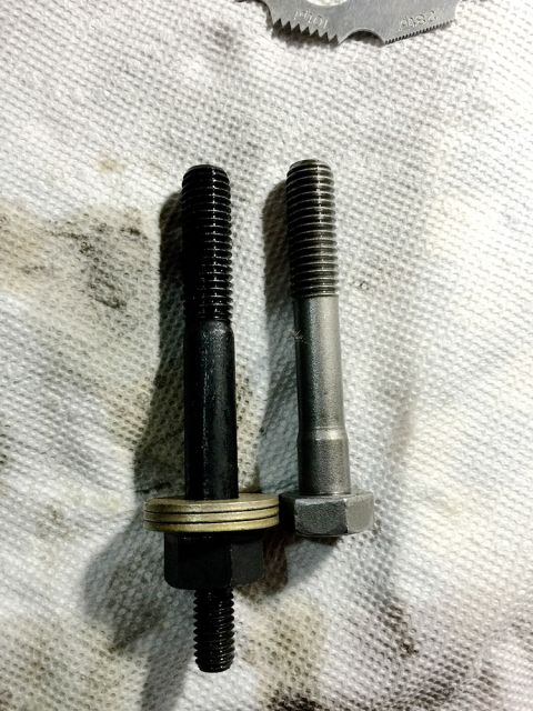 1978 Ford Bronco - Two bolts are shown on a white cloth. The bolt on the left is black and has three washers and a nut. The bolt on the right is silver and ap…