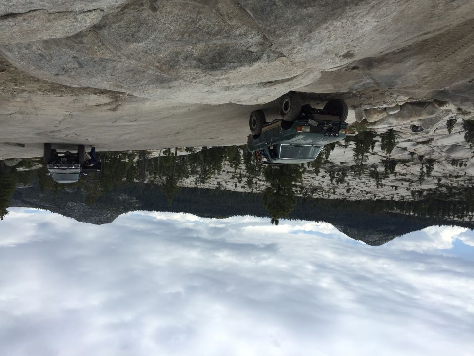 Two lifted pickups parked on bare granite mountains