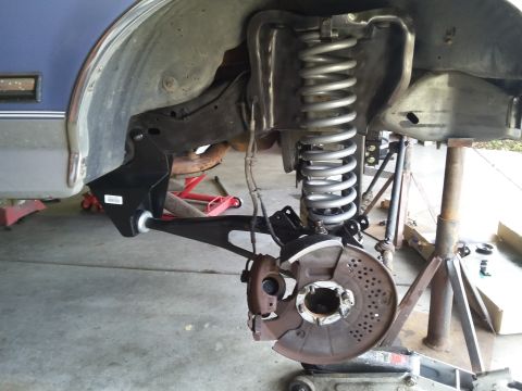 1996 Ford Bronco - The front suspension of a 1996 Ford Bronco is shown disassembled with a large coil spring, brake rotor, and control arm visible. The vehicl…