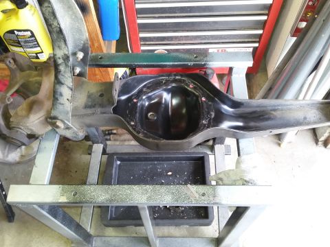 1996 Ford Bronco - A black differential housing assembly is mounted on a metal stand, with a yellow Prestone fluid bottle visible in the background.