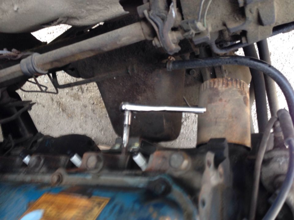 Ratchet wrench on spark plug of a blue engine