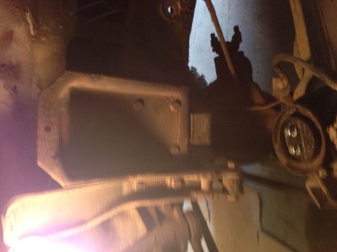 1979 Ford Bronco - A close-up, low-angle view of the underside of a vehicle, focusing on a metal component that appears to be part of the drivetrain or suspen…