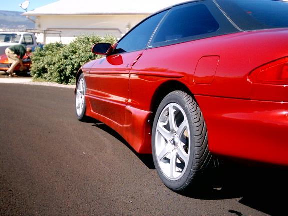 Red Ford Probe with custom body kit and aftermarket wheels, side view.