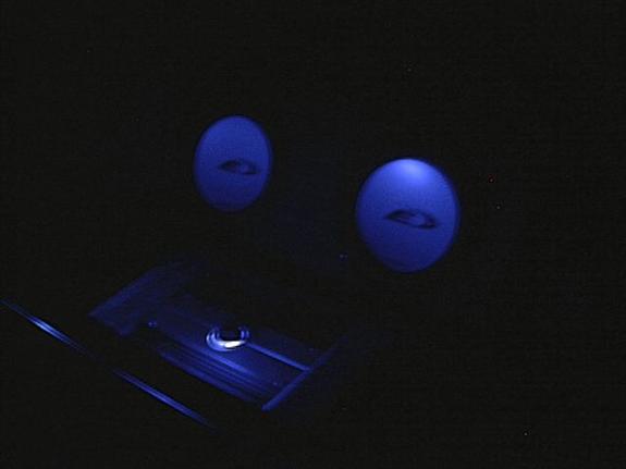 Two blue orbs with dark centers above a blue illuminated car interior object.