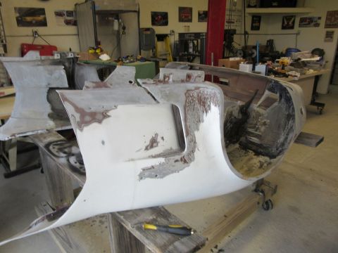 Car body panels undergoing repair in a workshop setting