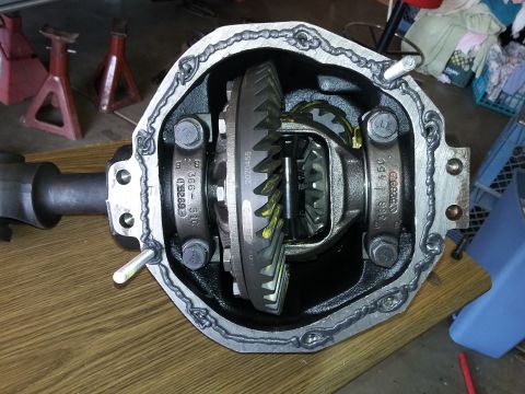 1996 Ford Bronco - A differential housing with a gear set visible inside, sealed with a bead of grey sealant. The housing is mounted on a wooden surface with…