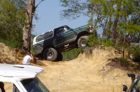 1993 Ford Bronco - A classic Ford Bronco navigates a challenging off-road trail with steep inclines.