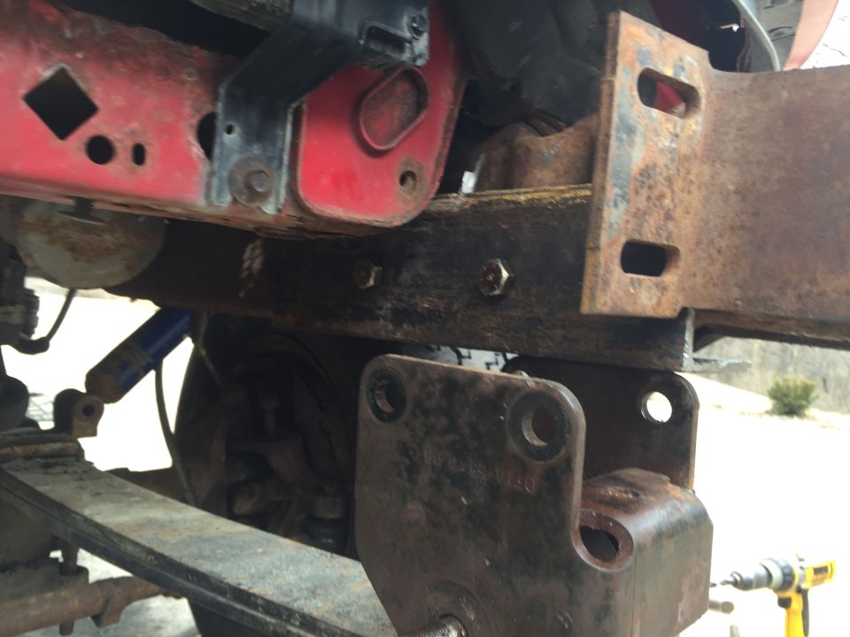 rusted truck frame with suspension parts