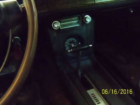 1968 Mercury Cougar - The interior of a car features a vintage radio and a gauge below it, with a gear shifter in the center console.