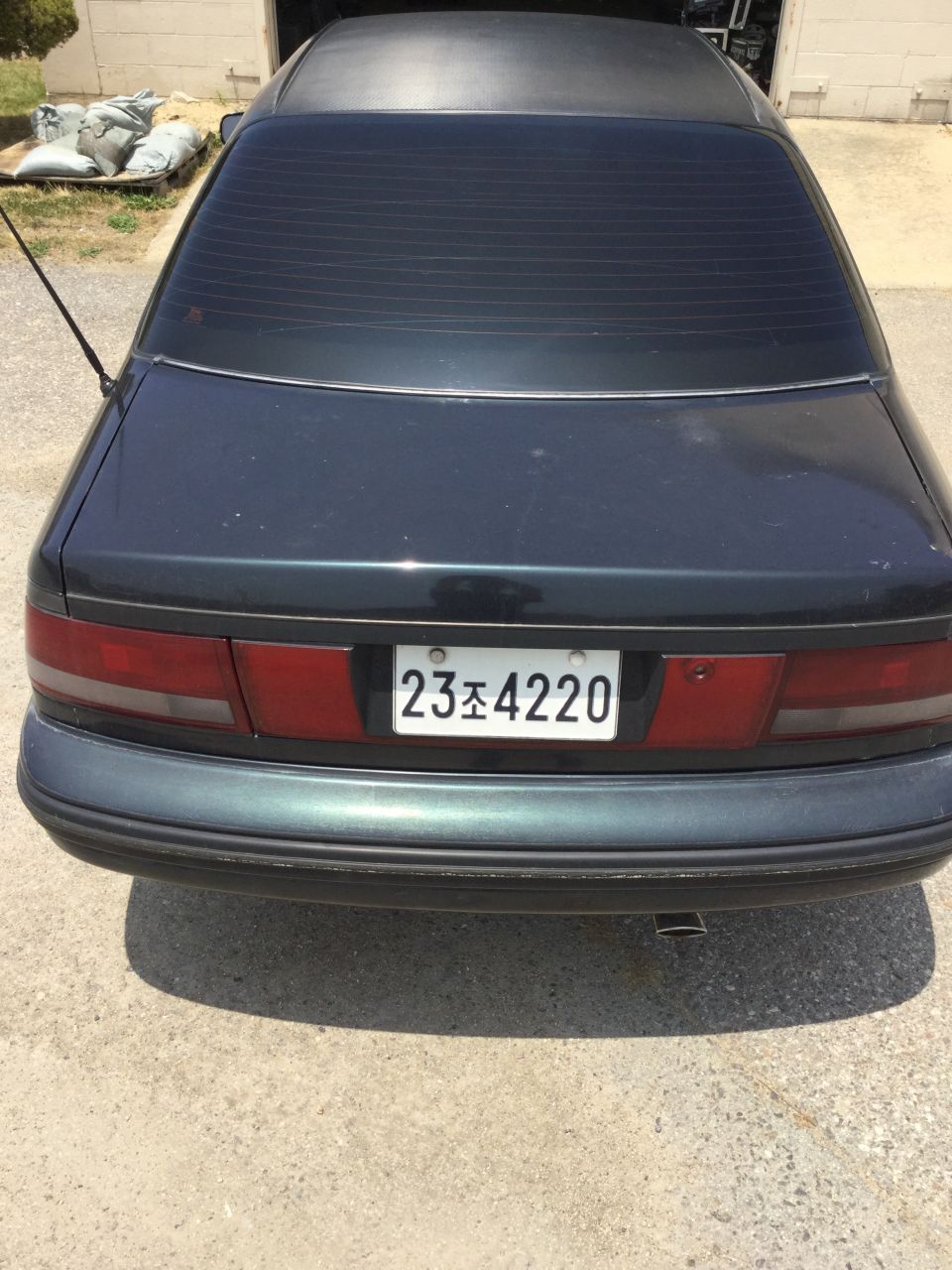 Rear view of a dark sedan with a license plate reading 23조 4220