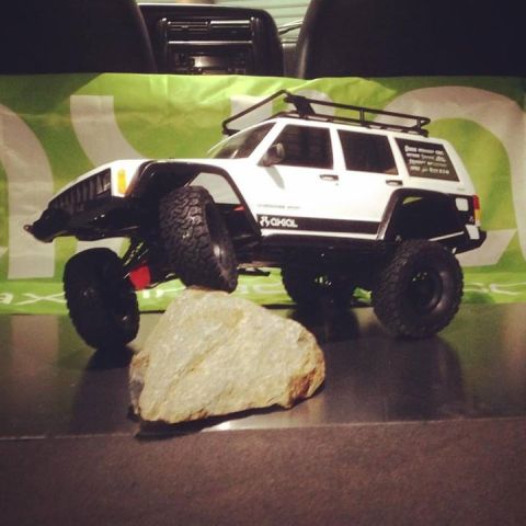 1989 Ford Bronco - RC rock crawler on a rock, with 'Axial SCX10 II' text visible on the side.