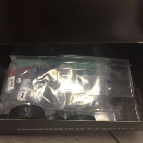 1989 Ford Bronco - A clear plastic truck body and tires are packaged in a box with the text 'ENGINEERED TO GO THE DISTANCE' printed on the front.