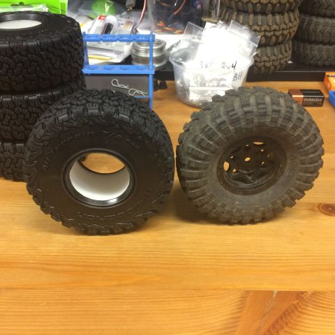 1989 Ford Bronco - Comparison of a new and used RC car tire, with other tires and parts in the background.