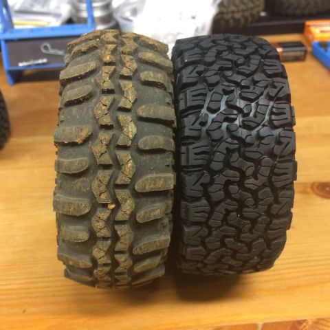 1989 Ford Bronco - Comparison of a used, muddy off-road tire next to a new, black off-road tire.
