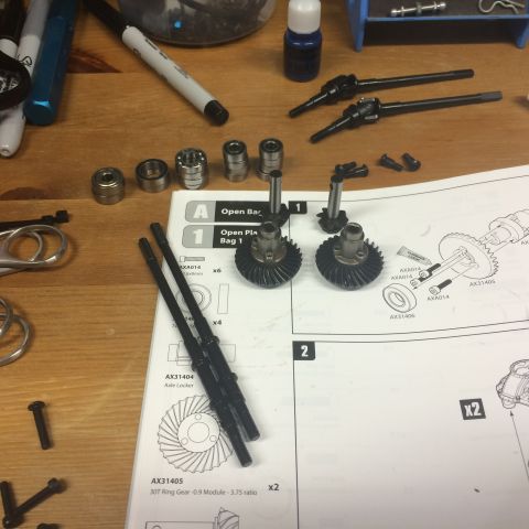1989 Ford Bronco - Assembly instructions and parts for a remote-controlled car are spread out on a wooden surface.