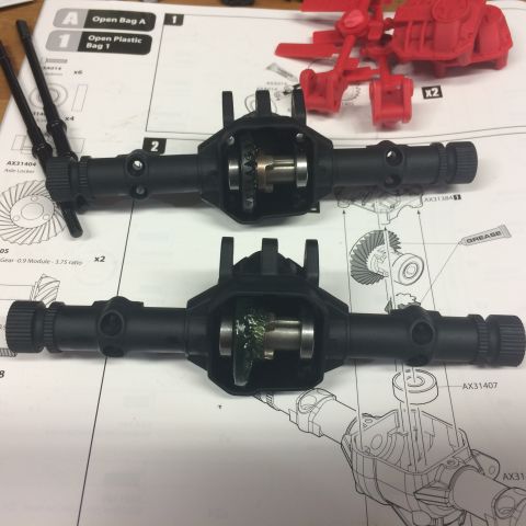 1989 Ford Bronco - RC car axle assemblies are shown with gears and grease, placed on top of assembly instructions.
