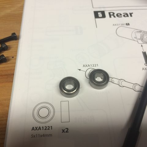 1989 Ford Bronco - RC car manual page detailing part AXA1221, with two bearings and screws shown.