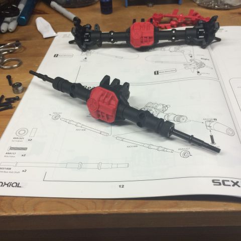 1989 Ford Bronco - Two unassembled RC car axles are laid out on a page of assembly instructions.