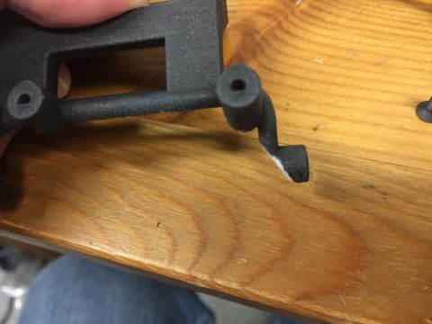 1989 Ford Bronco - A close-up view of a black plastic component resting on a wooden surface.