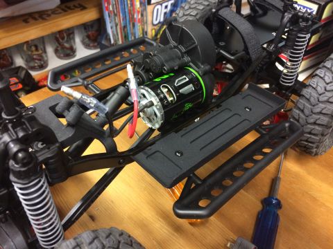 1989 Ford Bronco - Close-up view of the chassis and motor assembly of an RC car, showing suspension and drivetrain components.
