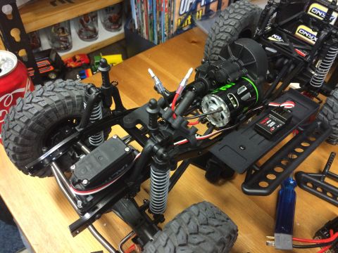 1989 Ford Bronco - Close-up of an RC car chassis, showing the motor, electronics, and suspension components.